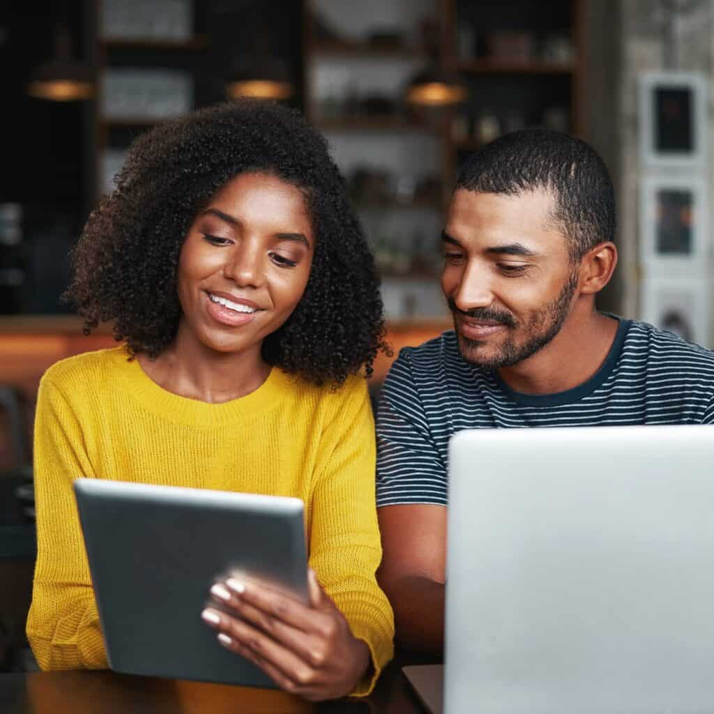 Man and Woman Comparing Websites on Devices